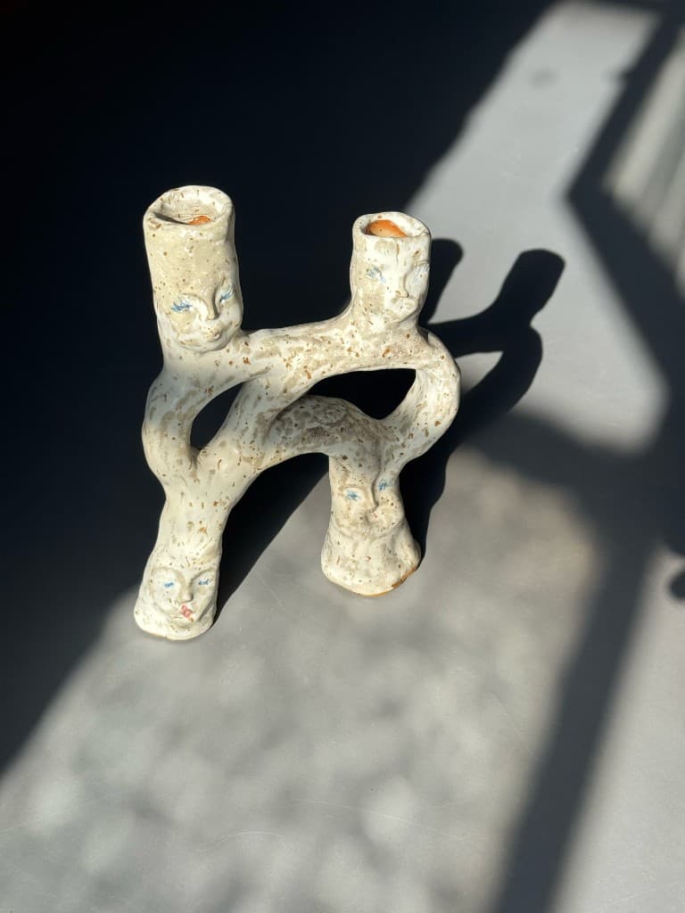 Keramisk lysestage med små ansigter
